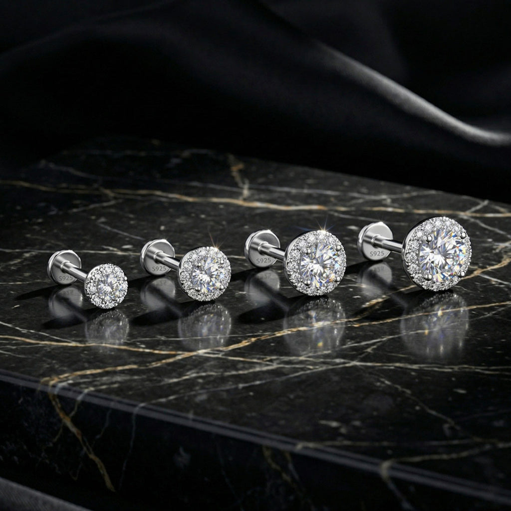 Set of diamond stud earrings on a black marble surface