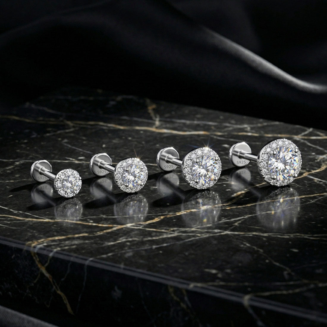 Set of diamond stud earrings on a black marble surface